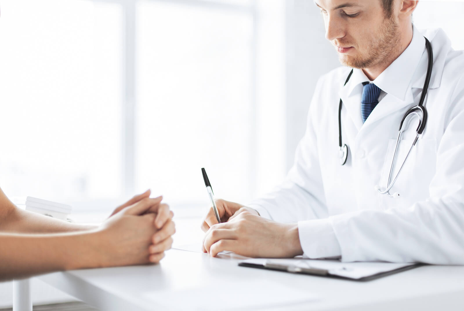 close up of patient and doctor taking notes